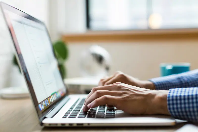 Hands typing on a laptop keyboard.