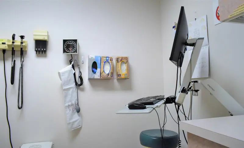 A medical office wall with a phone and supplies.